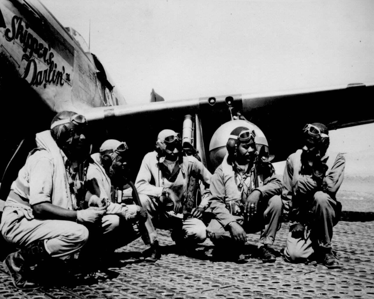 Tuskegee Airmen pilots beside a P-51 Mustang