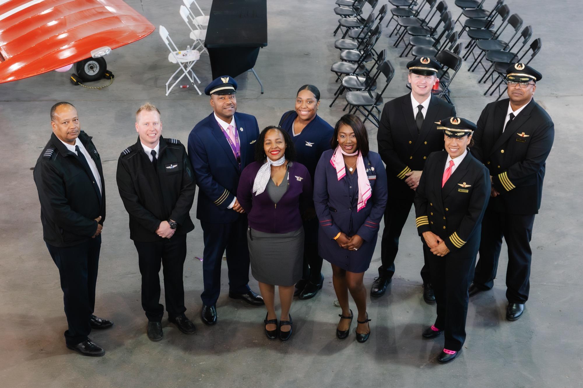 Museum staff and volunteers posing with a vintage aircraft
